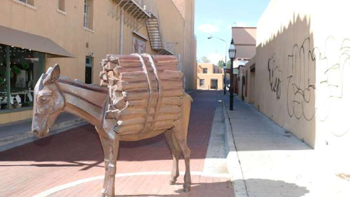 Santa Fe works to place tail of the donkey statue