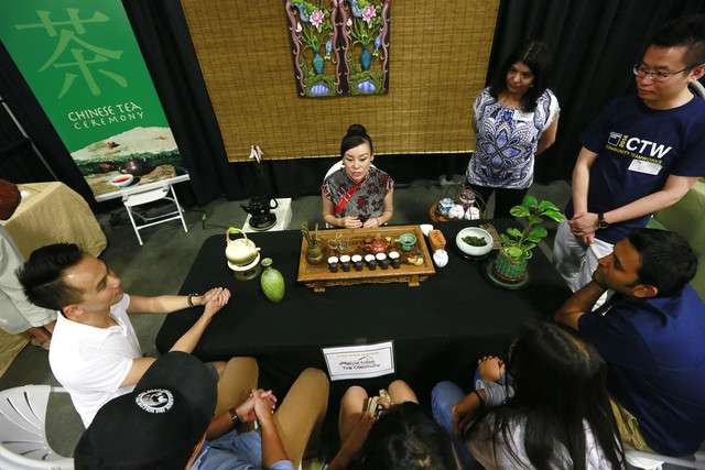 Tea Artist Luoya Hunt talks to her guests during the Utah Asian
Festival at the South Towne Exposition Center Saturday, June 14,
2014, in Sandy.