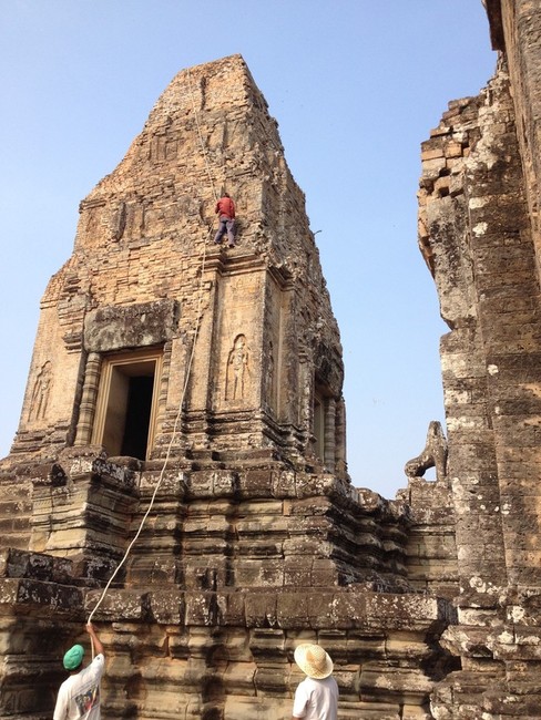 ANGKOR, CAMBODIA: "The man climbing is deaf & 
mute, and his job is to scale the temples & 
get rid of the shrubbery growing on the 
ancient structures. He works without shoes or 
gloves." - CNN's Madison Park. Built in the 
early 12th century, and encompassing an area 
of about 500 acres (200 hectares), Angkor Wat 
is one of the largest religious monuments 
ever constructed. Its name means "temple 
city."