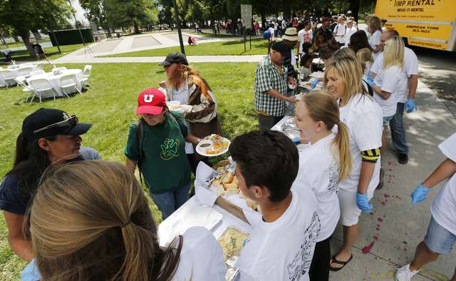 Tanner Larsen and Mariah Genck feed the homeless at Pioneer Park in
Salt Lake City Friday, June 27, 2014. The couple will be married
Saturday and wanted to forego the traditional wedding luncheon to
feed the homeless. (Photo: Jeffrey D. Allred, Deseret News)