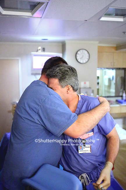 "Dad and doc embraced and cried and it took my
breath away. That is still the umbilical cord
in the doc's hands to tell you how immediately
this happened after delivery." -Photographer
Sarah Ledford