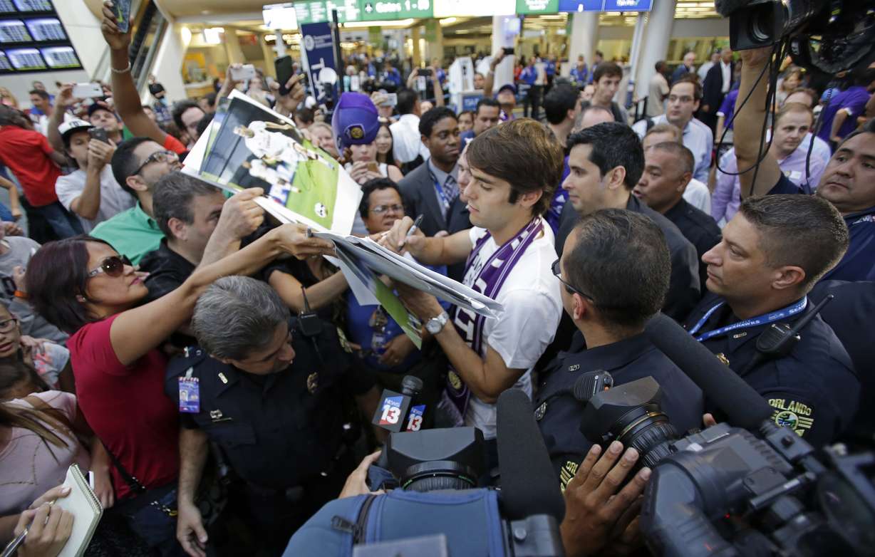 Brazilian soccer star Kaka, center, signs autographs as he is surrounded by fans at Orlando International Airport, Monday, June 30, 2014, in Orlando, Fla. Kaka is the first designated player to sign with the Orlando City Soccer Club. (AP Photo)