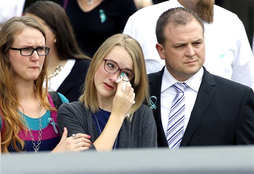 Cassidy Stay, center, wipes her eye as she watches the caskets of her family members loaded into waiting hearses outside The Church of Jesus Christ of Latter-day Saints after a funeral service for her family Wednesday, July 16, 2014, in Houston. Slaying victims Stephen Stay, 39, his 34-year-old wife, Katie, and their four youngest children were shot to death last week in their suburban Houston home. The oldest child Cassidy, 15, survived the attack by playing dead, called police and identified her uncle, 33-year-old Ronald Lee Haskell, as the gunman. (AP Photo/David J. Phillip)