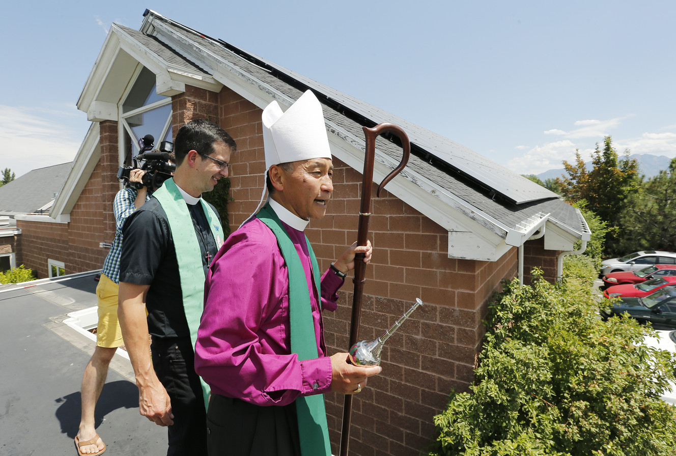 The Rev. Scott B. Hayashi, 11th bishop of the Episcopal Diocese of 
Utah, and the Rev. Matthew T. Seddon, vicar of St. Stephen's Episcopal 
Church, bless the solar panels and congregation of the St. Stephens 
Episcopal Church in West Valley City on Sunday, July 20, 2014.
