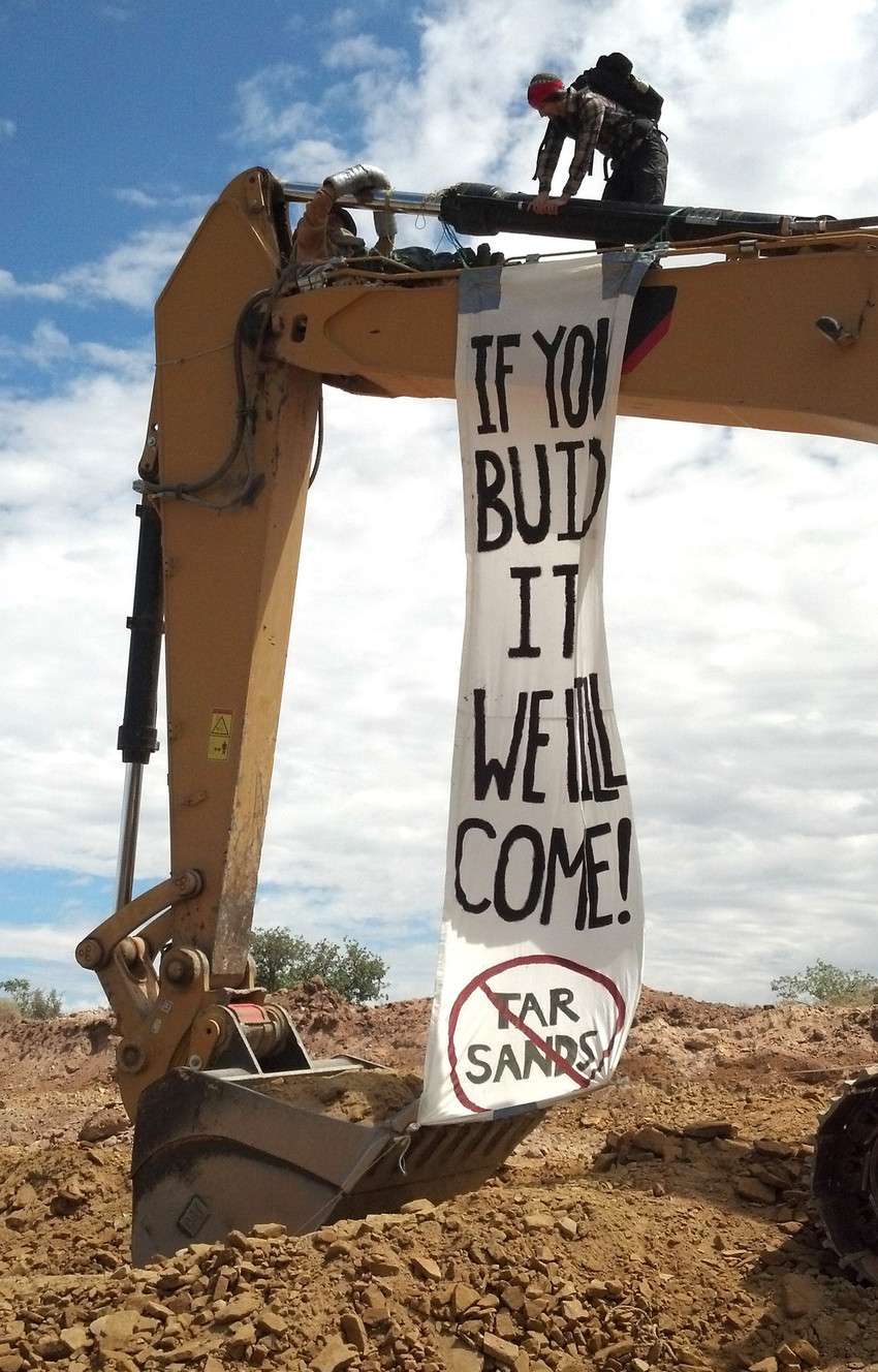 Protesters from a number of environmental
groups shut down construction on the Seep
Ridge Road in Uintah County on July 29, 2013,
as part of a "direct action" against U.S. Oil
Sands' plan to develop tar sands on land
leased from the Utah Schools and
Institutional Trust Lands Administration. A
similar "direct action" on Monday, July 21,
2014, resulted in 21 protesters from 10
states being arrested. (Photo: Geoff Liesik,
KSL TV)