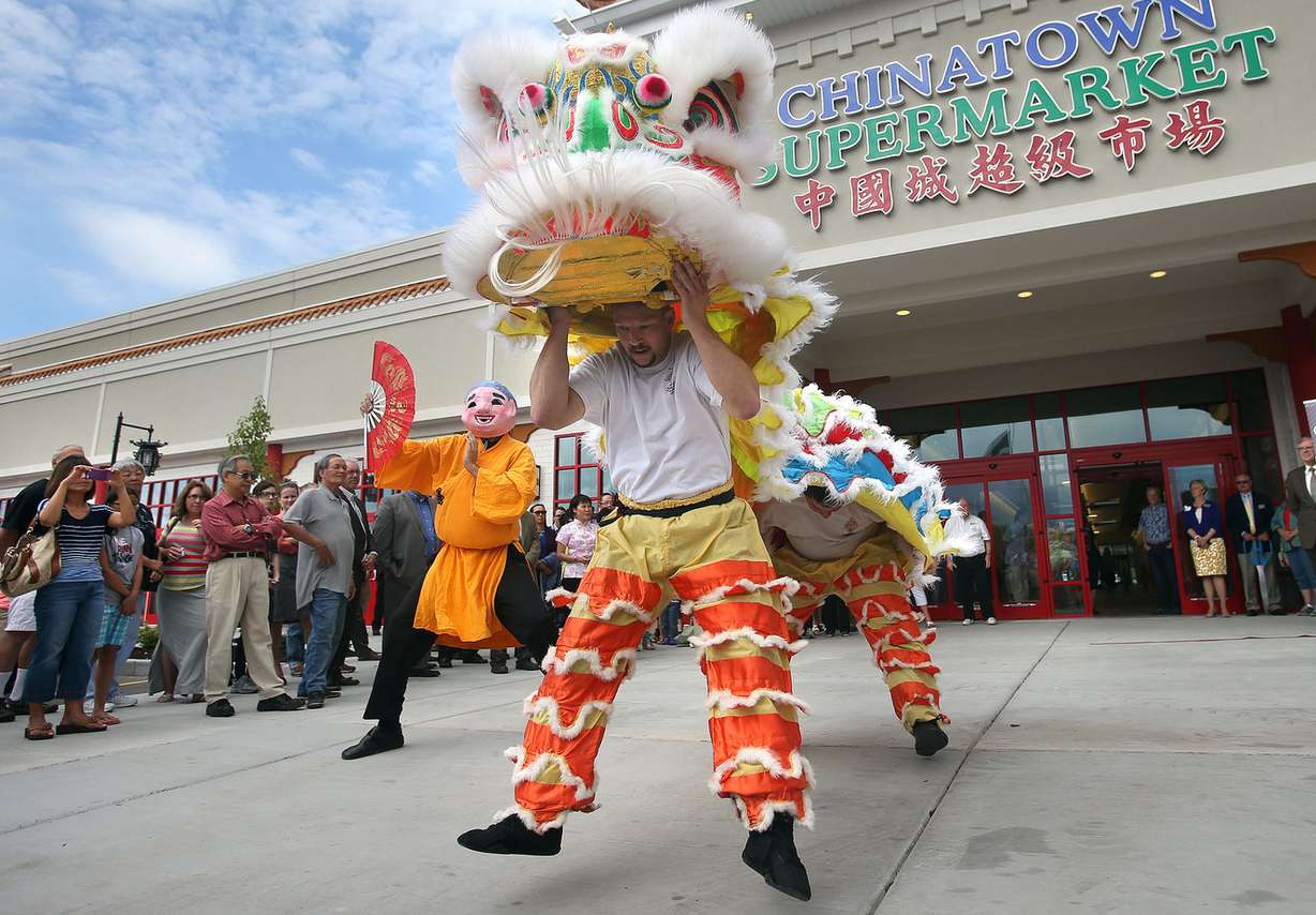 A lion dance entertains people at the ribbon cutting and grand opening of the Chinatown Supermarket in South Salt Lake City on Wednesday, July 30, 2014.