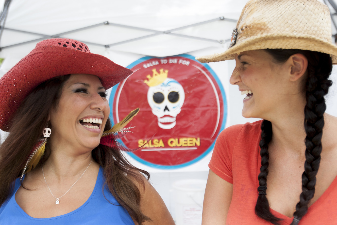 Maharba Howell, left, laughs as she runs her Salsa Queen stand with Jacque Bond during the farmers market at Wheeler Historic Farm on  Aug. 3, 2014.