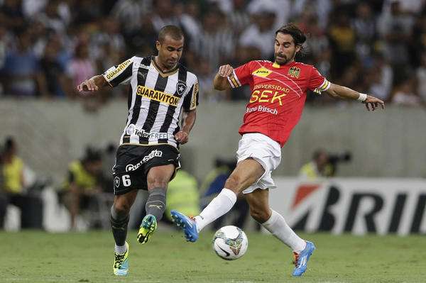 Julio Cesar of Brazil's Botafogo, left, fights for the ball with Sebastian Oscar Jaime of Chile's Union Espanola at a Copa Libertadores soccer match in Rio de Janeiro, Brazil, Wednesday, April 2, 2014. (AP Photo/Felipe Dana)