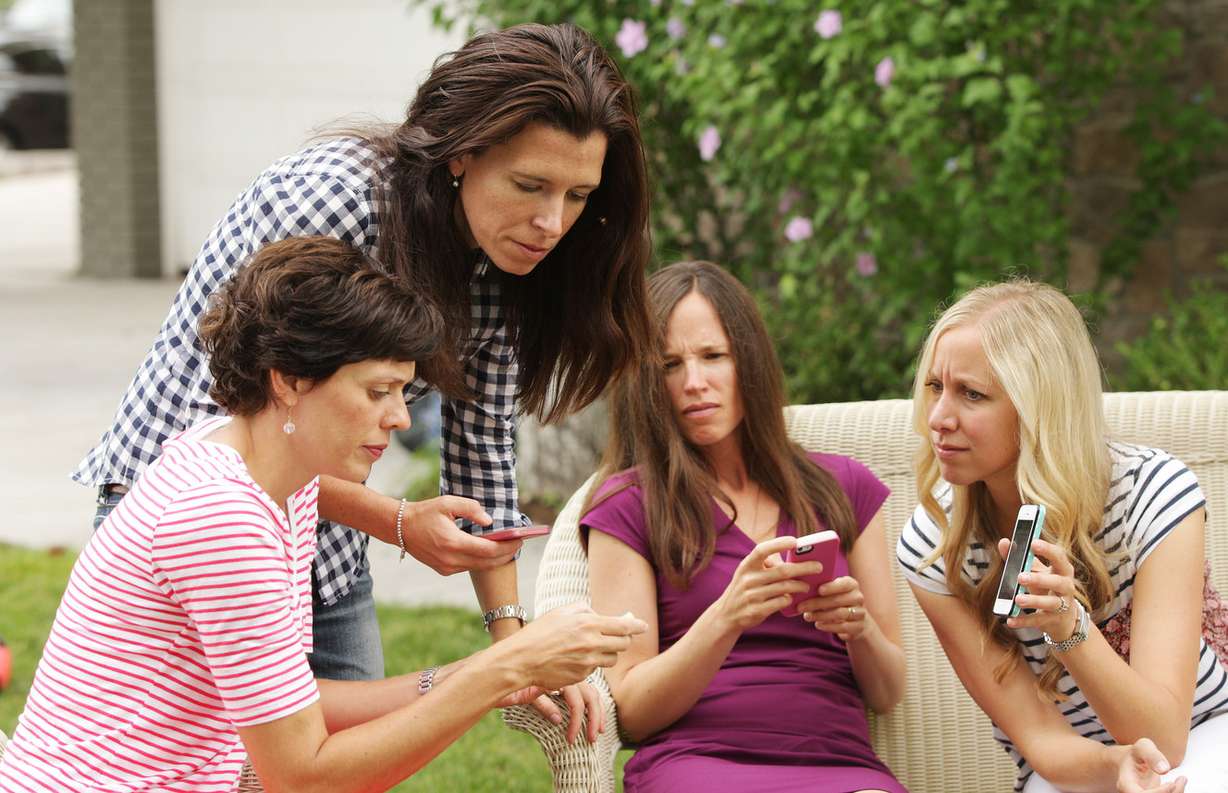 Catherine Arveseth, left, Erica Flitton, Liz Smith and Lynley Johnson, parents of school-aged children look over a new app to organize groups for safe walking and biking to school in Holladay Tuesday, Aug. 12, 2014. UDOT's Walking School Bus app is a free, safety-focused app, for iPhone and Andoid, that encourages parents to create and plan walks safely to and from school. It also alerts parents when students have arrived at school.