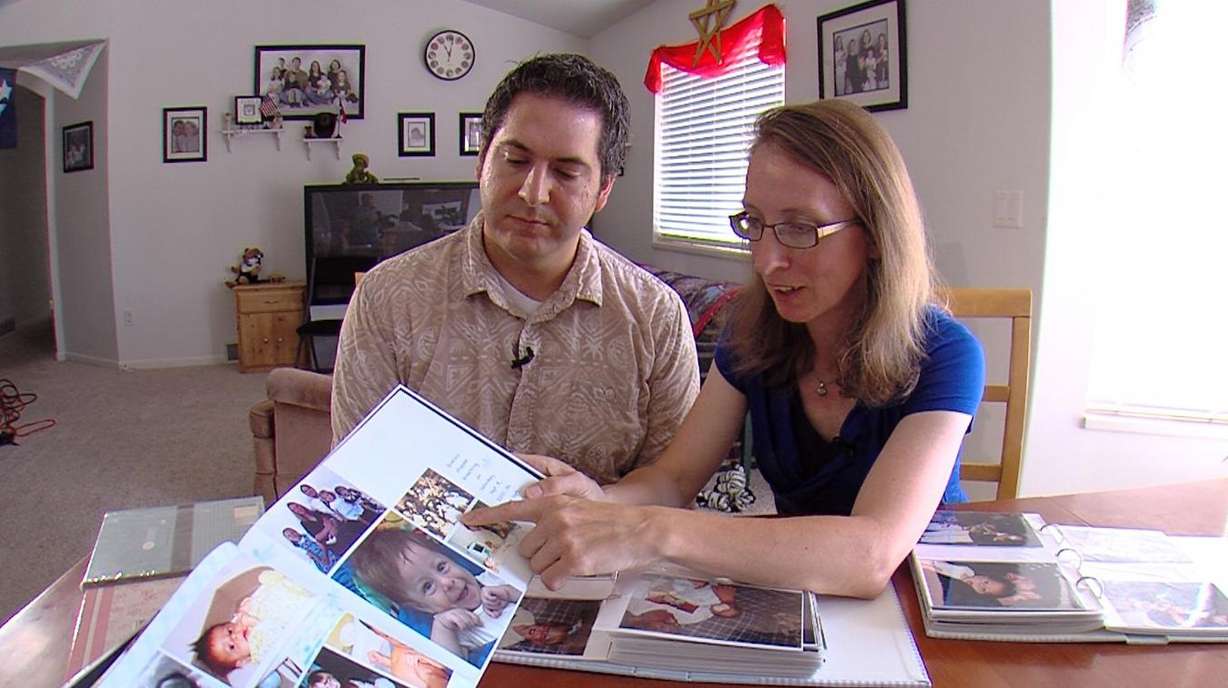 Chris and Marie Nuccetelli, of Lehi, look at photos of their boy who died in 2001. They also lost a girl in 2007. Both babies had undiagnosed conditions. (Photo: Ken Fall, KSL TV)