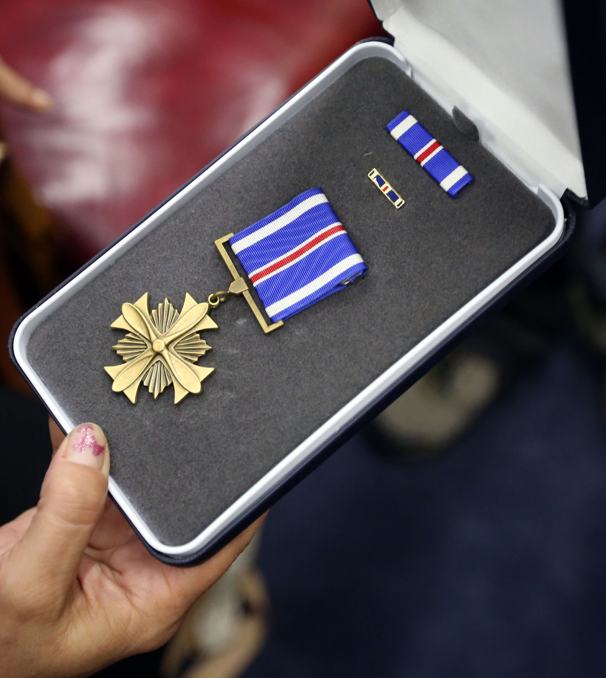 Andrea Madsen holds her late grandfather's Distinguished Flying Cross, a military medal bestowed on those who distinguish themselves in "support of operations by heroism or extraordinary achievement while participating in an aerial flight," in Sen. Orrin Hatch's office in Salt Lake City on Thursday, Aug. 14, 2014. First Lt. Boyd Madsen earned the award in 1945