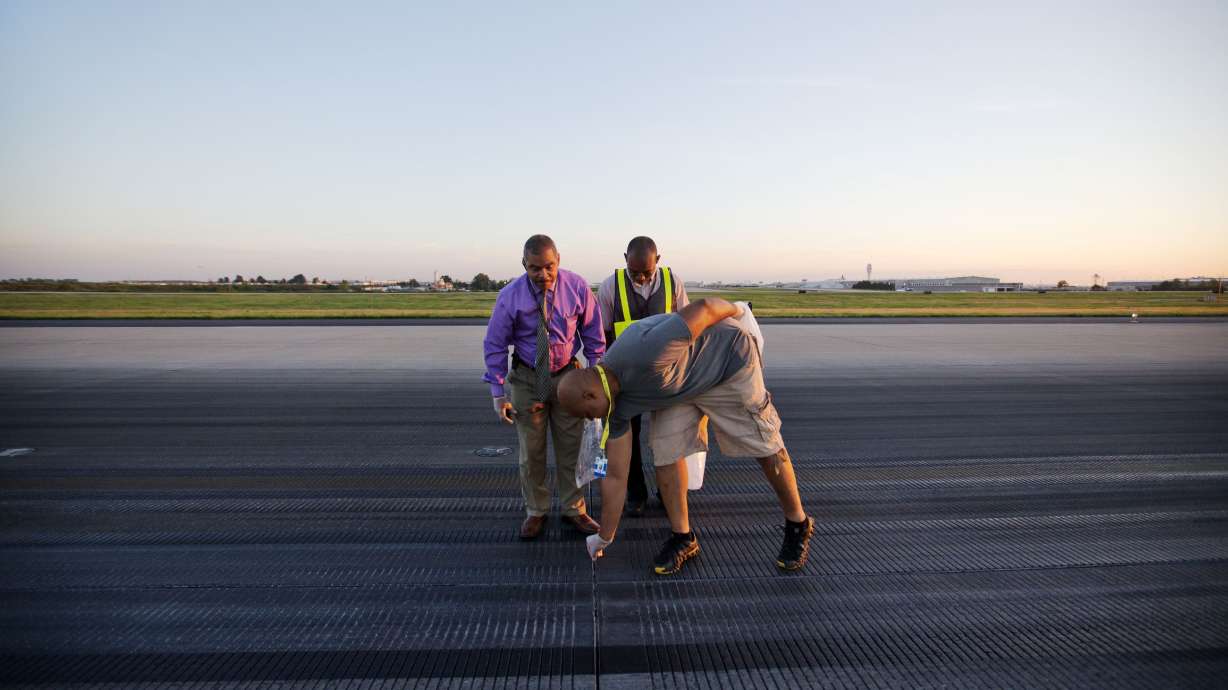 AP PHOTOS: Workers clear debris from busy runway