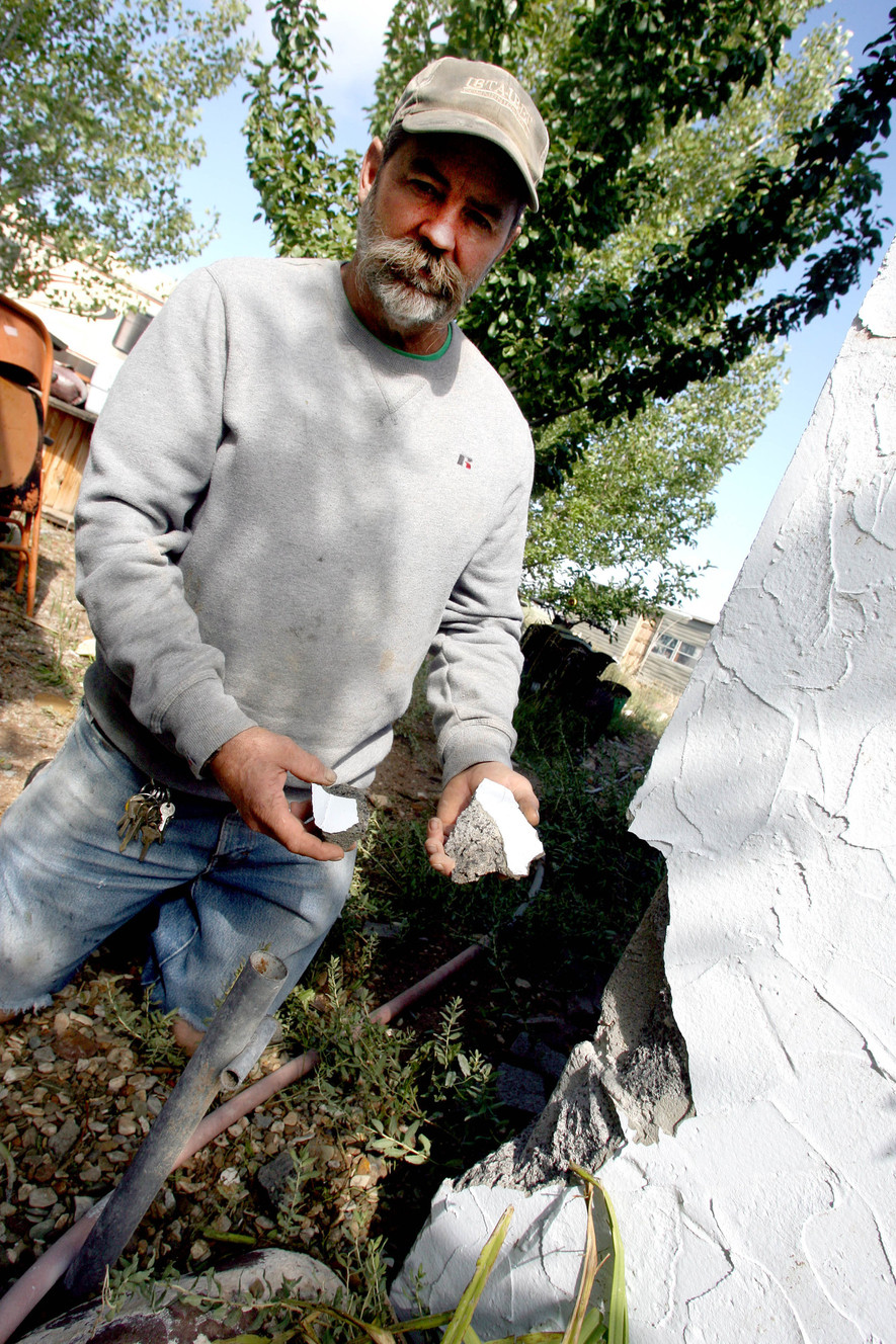 Robert Taylor holds up two pieces of cinderblock that were blasted out of the side of his castle by an Aug. 25, 2014, lightning strike. Taylor, who has spent the past 11 years building the castle on the North Myton Bench in Duchesne County, does not plan to repair the damage because "it gives the castle character." Credit: Geoff Liesik, KSL
