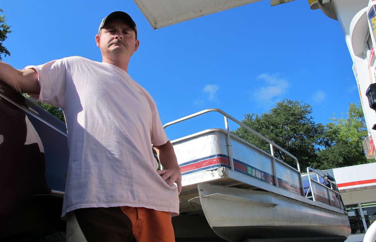 In this Aug. 29, 2014 photo, Waldo, Fla., resident Mike Barrs fills up his truck with gas in Waldo.