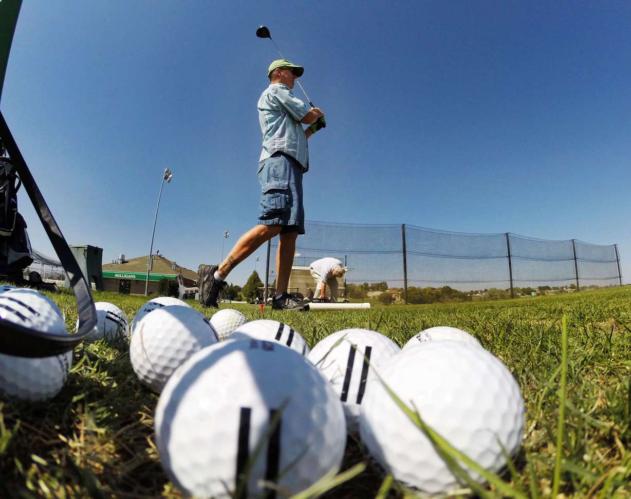 Mike Geer watches his ball as golfers enjoy Mulligans Tuesday, Sept. 2, 2014, in South Jordan.