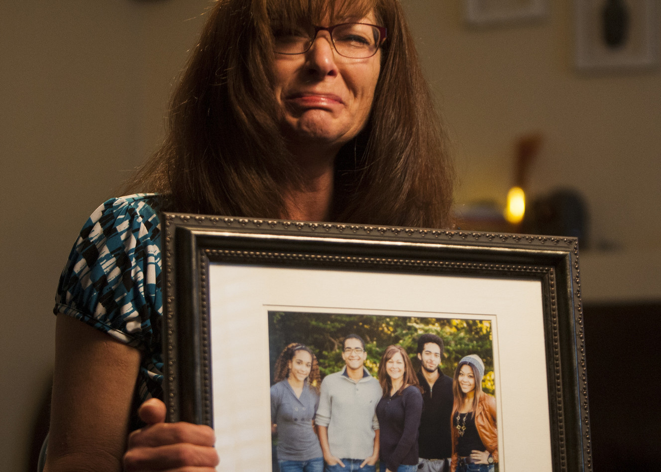 Susan Hunt holds a photo of her family, including her son, Darrien Hunt, who was killed by police Wednesday, at her home in Saratoga Springs, Friday, Sept. 12, 2014,