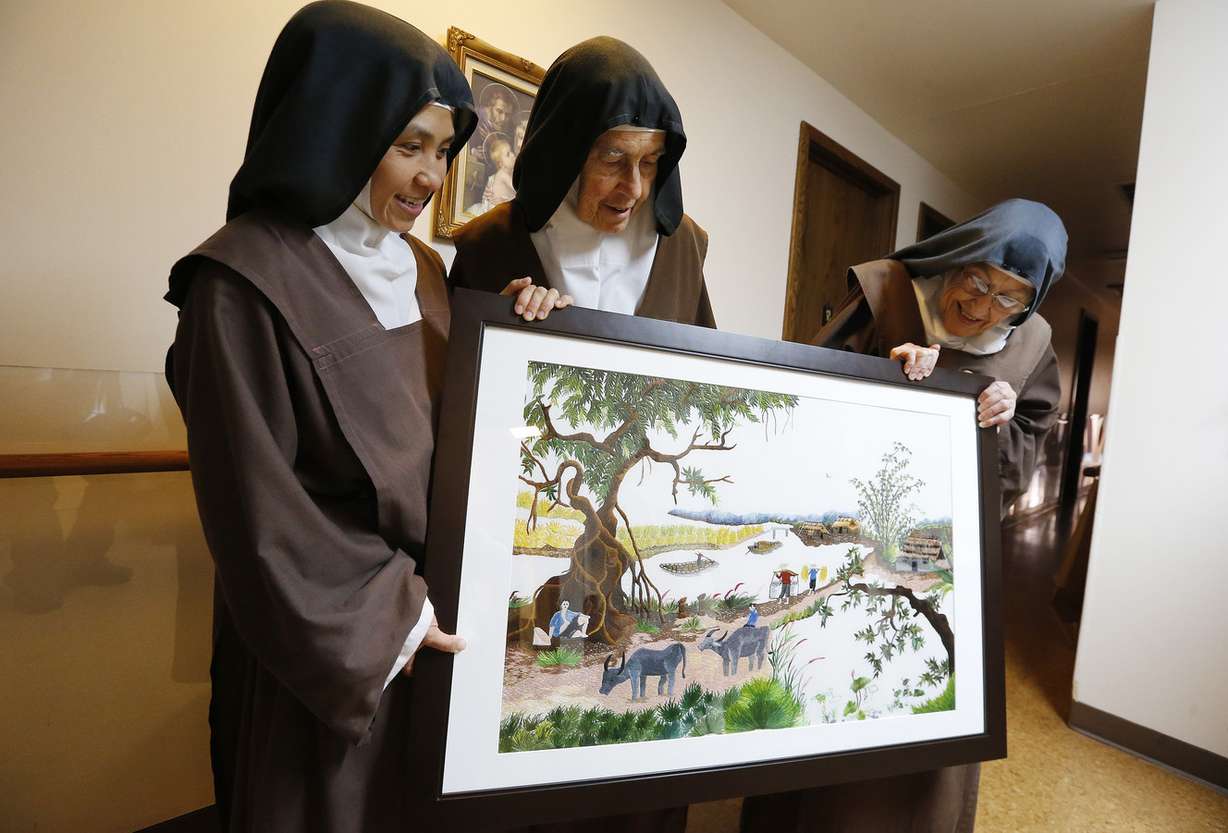 Sister Therese, Mother Maureen and Sister Margaret Mary look over an embroidery piece crafted by the nuns that took a year to complete and will be auctioned the Carmelite Fair in Holladay.