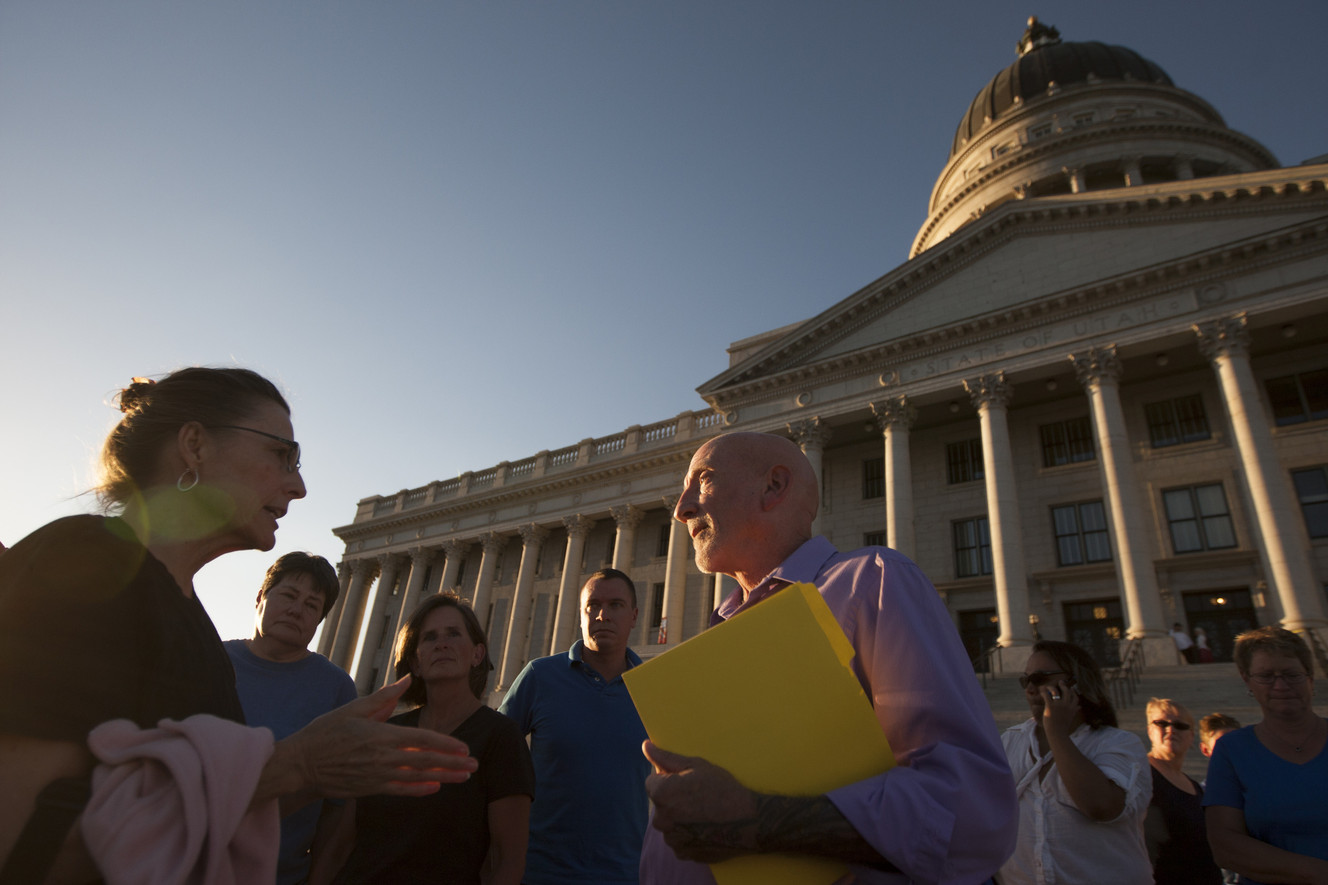 Restore Our Humanity founder Mark Lawrence debates with Barbara Roberts outside of a "Stand for Marriage" rally at the Utah State Capitol, Thursday, Sept. 18, 2014.
