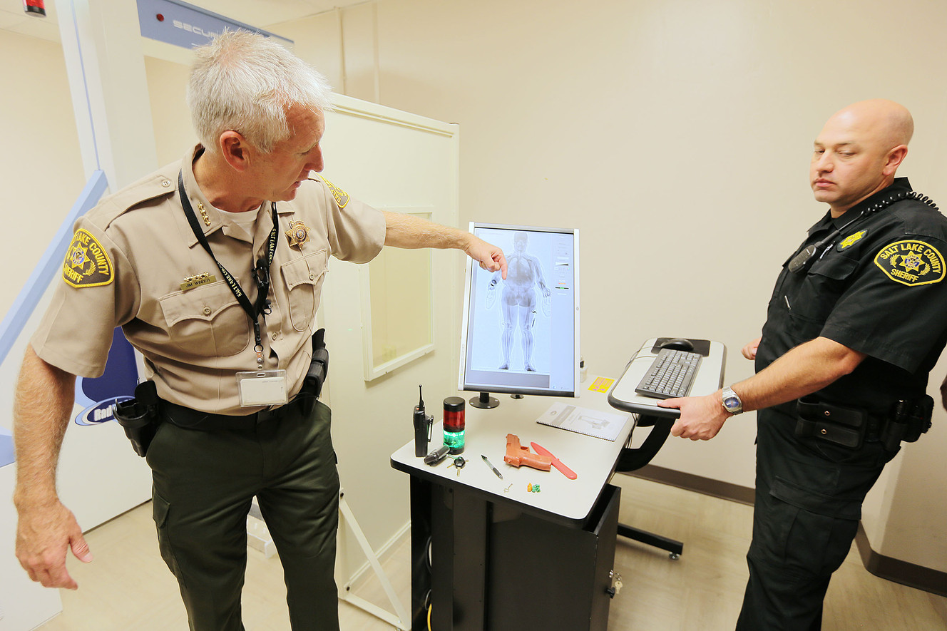 Salt Lake County Sheriff Jim Winder and scan technician officer Mark Hintze show how the scanner works as the sheriff announces Wednesday, Sept. 24, 2014, that the county jail will begin using a SecurPass whole body contraband detection scanner.