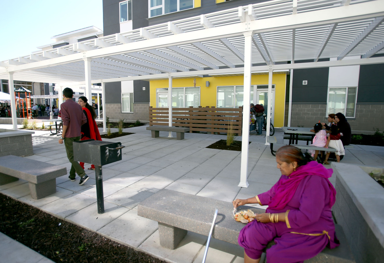 Residents gather outside the Bud Bailey apartments in Salt Lake City on Wednesday, Sept. 24, 2014. The new complex provides affordable housing for refugees and other low-income members of the local community.