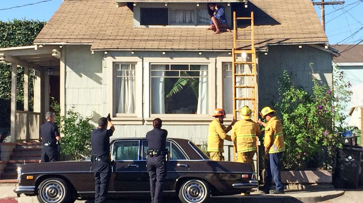LA woman evades intruder by climbing onto roof
