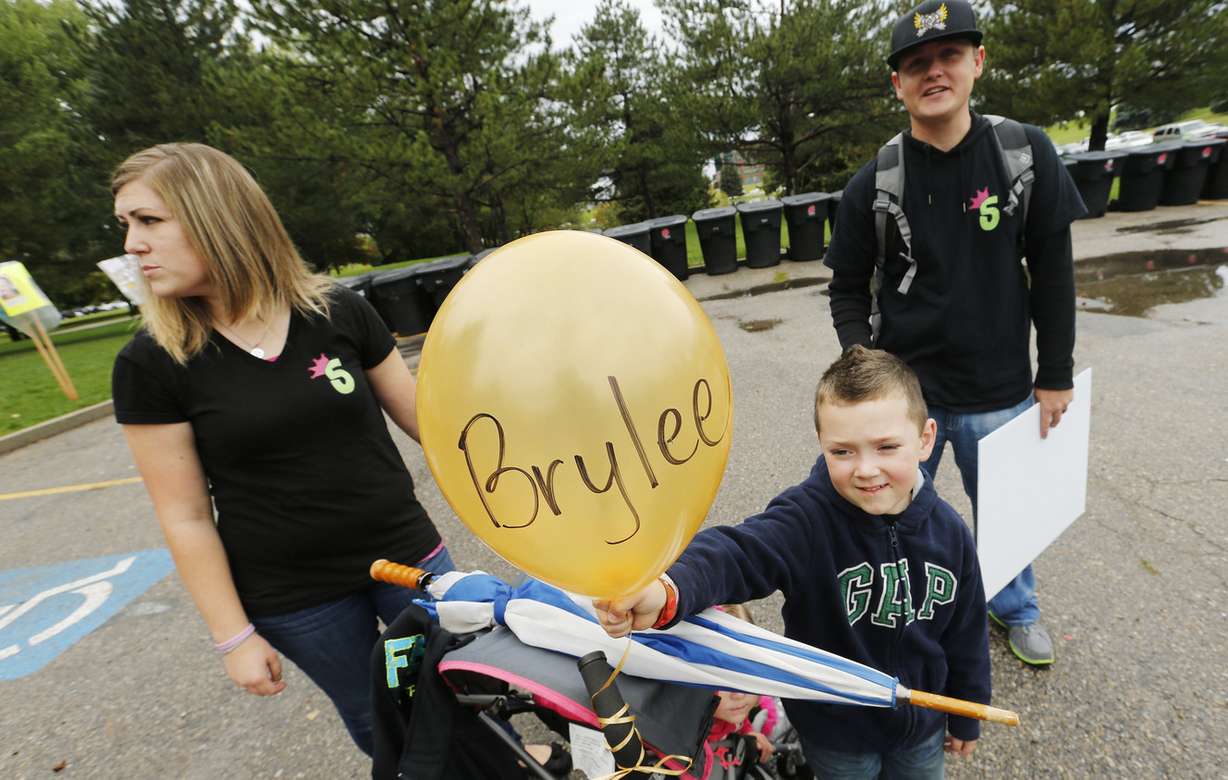 Cory and Lara Olson and their son Bryker participate in the CureSearch Walk at Sugarhouse Park in Salt Lake City Saturday, Sept. 27, 2014 to honor their daughter Brylee who passed away from cancer. The CureSearch Walk celebrates and honors children whose lives have been affected by childhood cancer, while raising funds for lifesaving research.