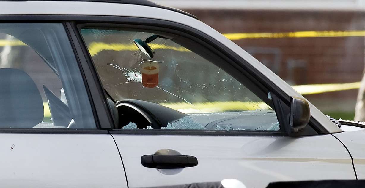 A shattered passenger side window and a bullet hole in the windshield are visible on one of two vehicles. West Valley Police officers investigate an officer involved shooting at the Lexington Park apartments near 3715 south and 2200 west Friday, Nov. 2, 2012. (Photo: Scott G Winterton, Deseret News)