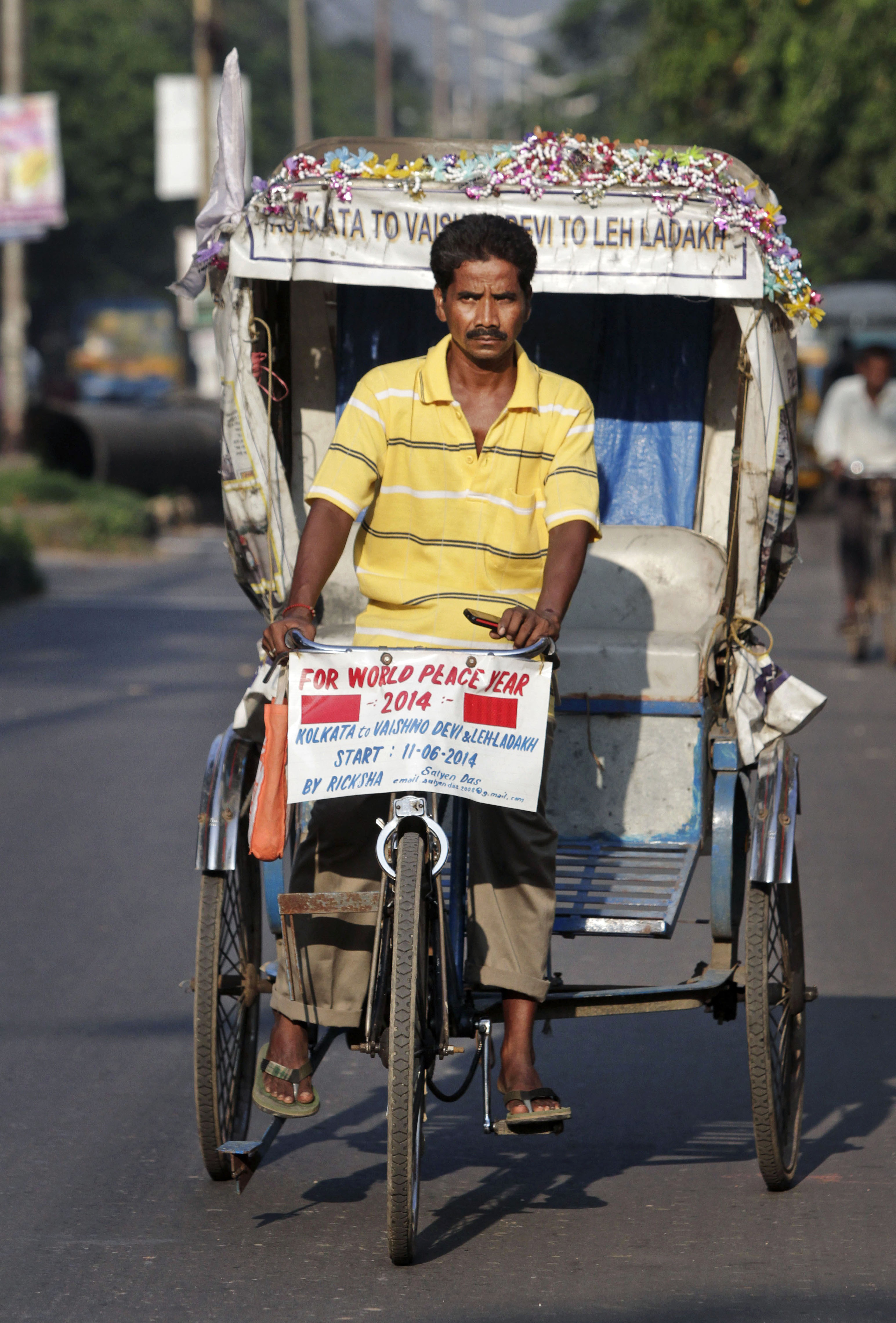 Indian man pedals cycle rickshaw to Himalayan pass
