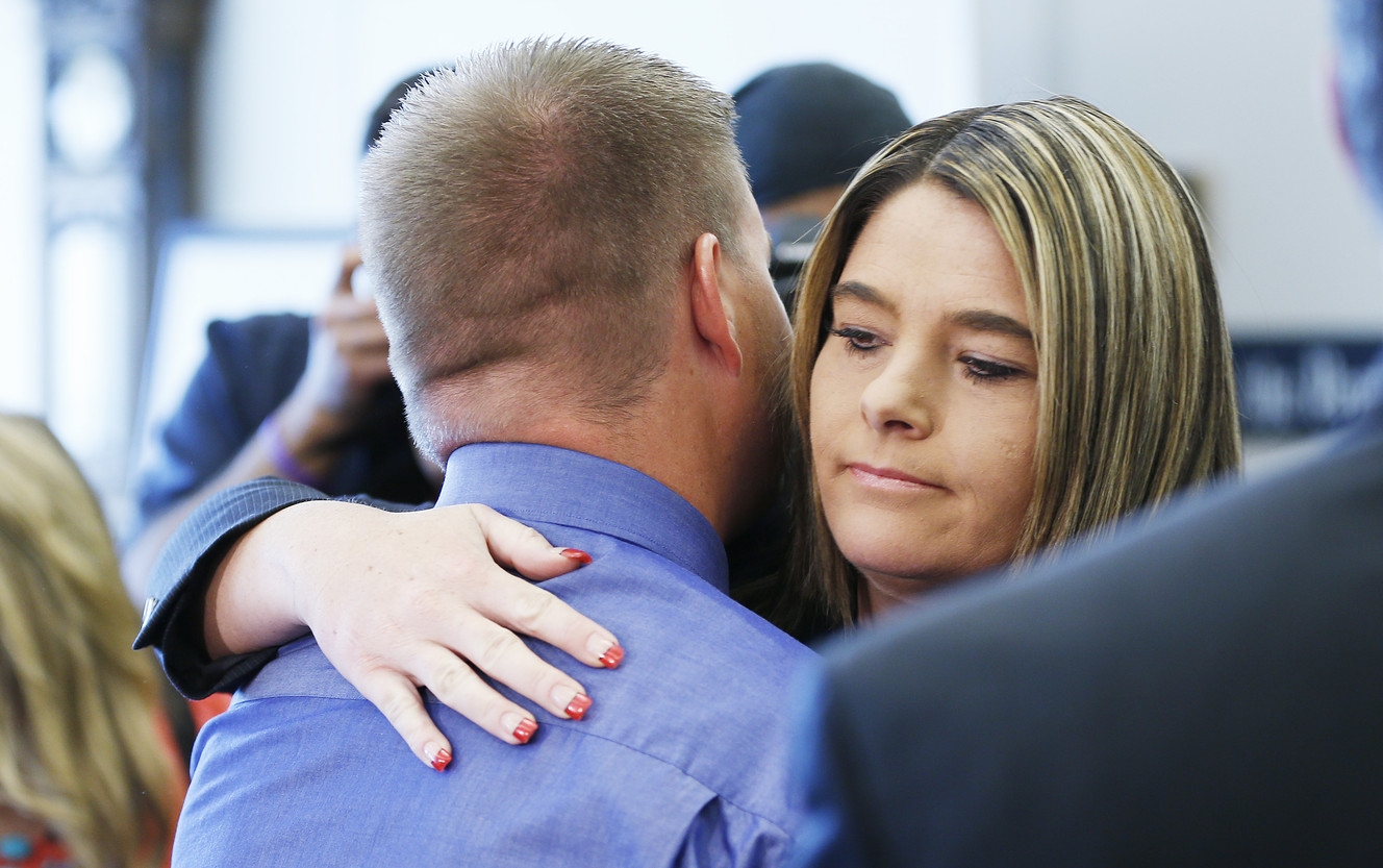 Defense attorney Lindsay Jarvis hugs her client and former West Valley police detective Shaun Cowley after his case of manslaughter was dismissed in Salt Lake City Thursday, Oct. 9, 2014.