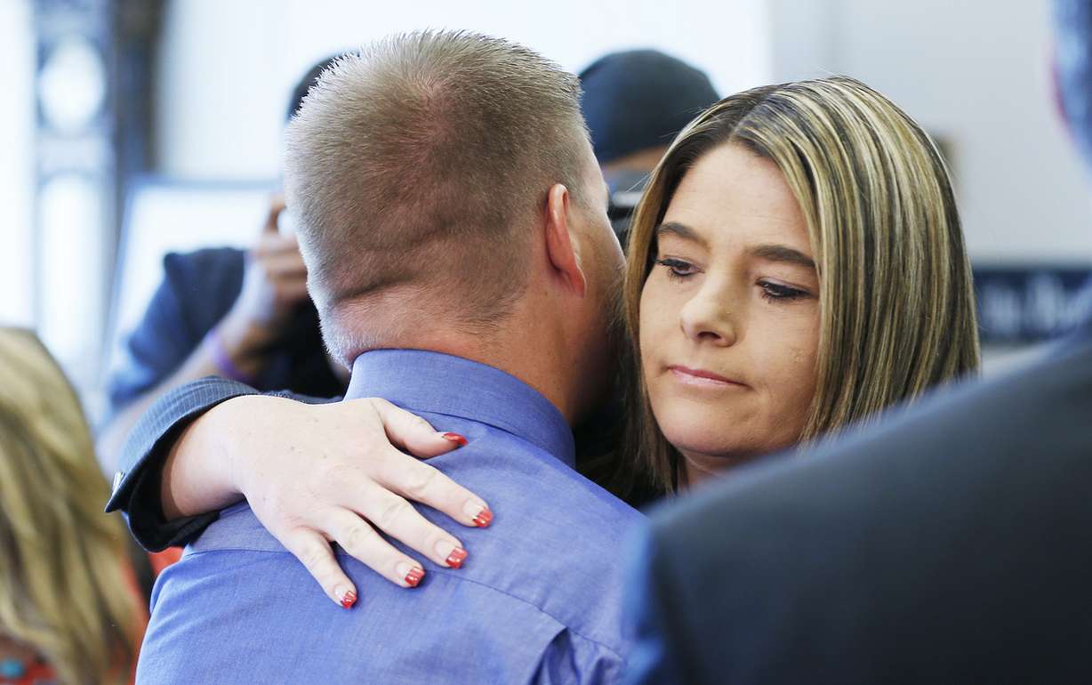 Defense attorney Lindsay Jarvis hugs her client and former West Valley police detective Shaun Cowley after his case of manslaughter was dismissed in Salt Lake City Thursday, Oct. 9, 2014.