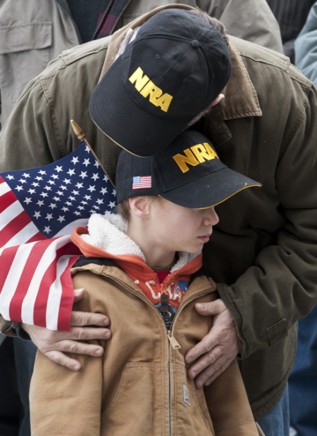 NRA supporter Kenny Deal of Stafford, Conn., hugs his son Daniel at rally at the Capitol in Hartford, Conn., Saturday, Jan. 19, 2013.