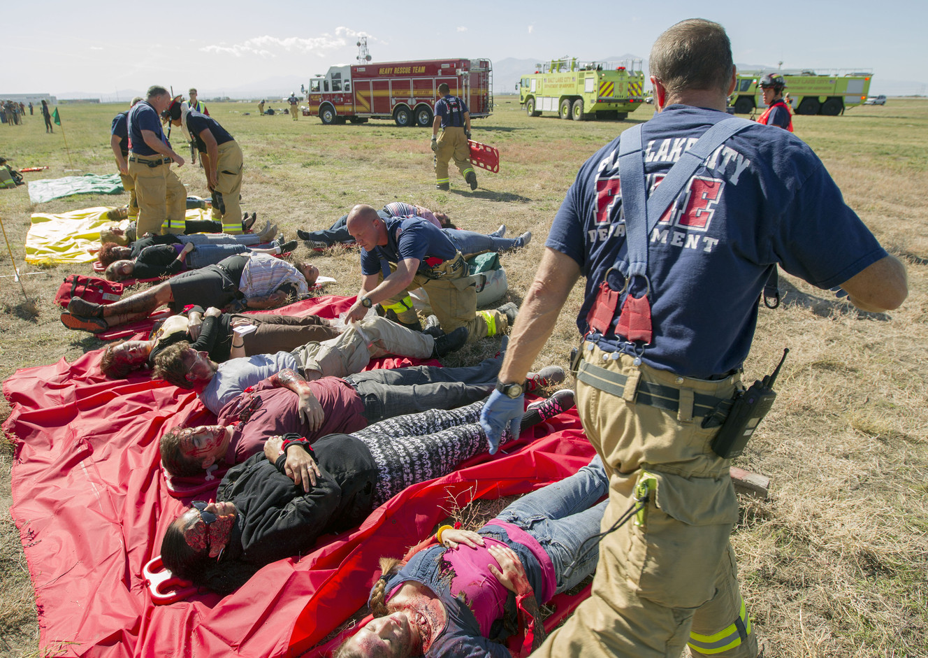Salt Lake City firefighters triage patients as Salt Lake City International airport conducts a mock crash scenario Friday, Oct. 10, 2014, at its training facility. Multiple agencies assisted in the drill.