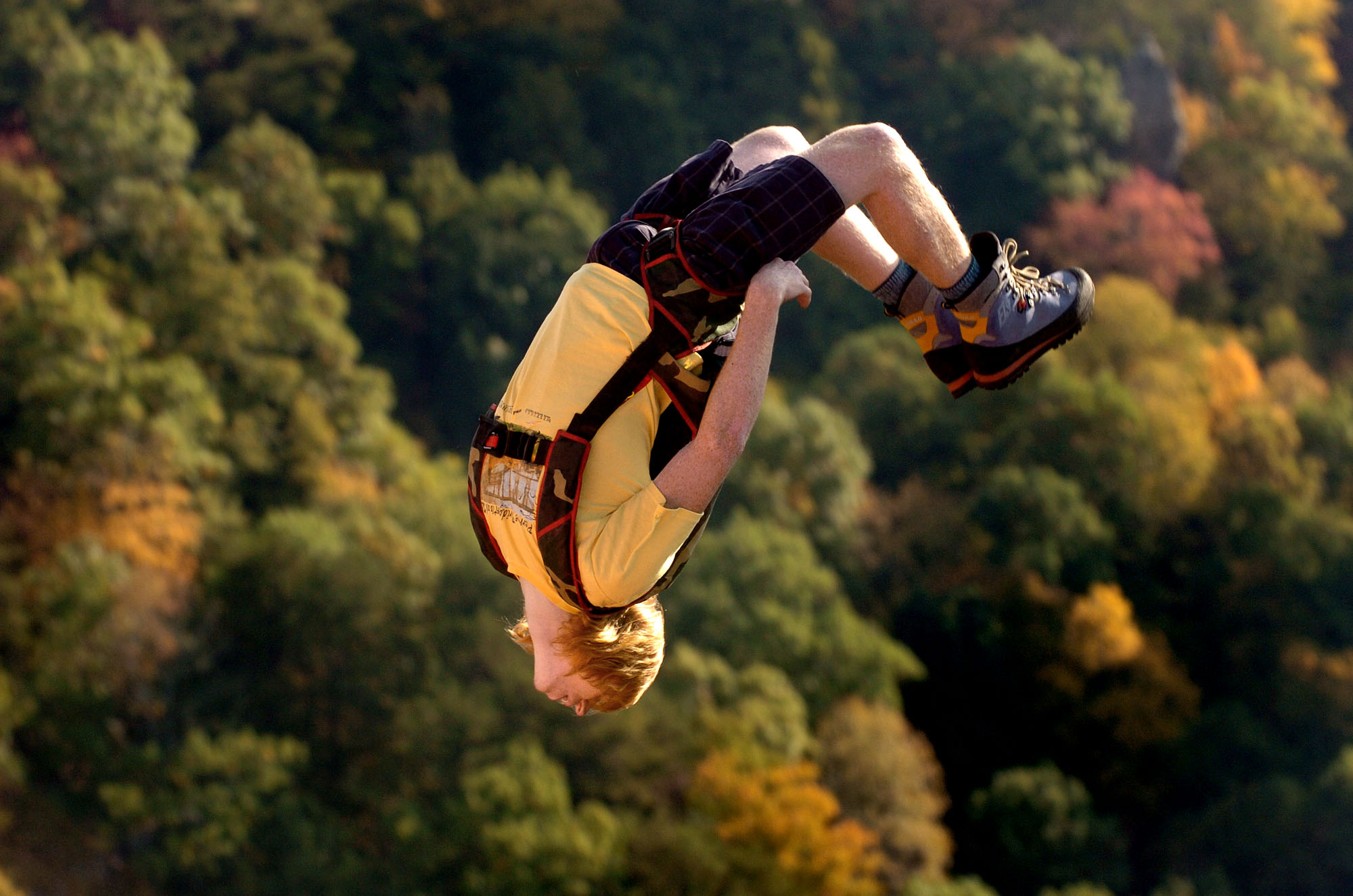 FILE - In this Oct. 20, 2007 file photo, Clayton Butler, 23, of Salt Lake City, Utah, does a gainer off the New River Gorge Bridge in Fayetteville, W.Va. on Bridge Day. Tens of thousands of people will watch scores of parachutists, zip liners and rappellers during the annual Bridge Day festival on Saturday, Oct. 18, 2014, in Fayetteville. (AP Photo/Jon C. Hancock)