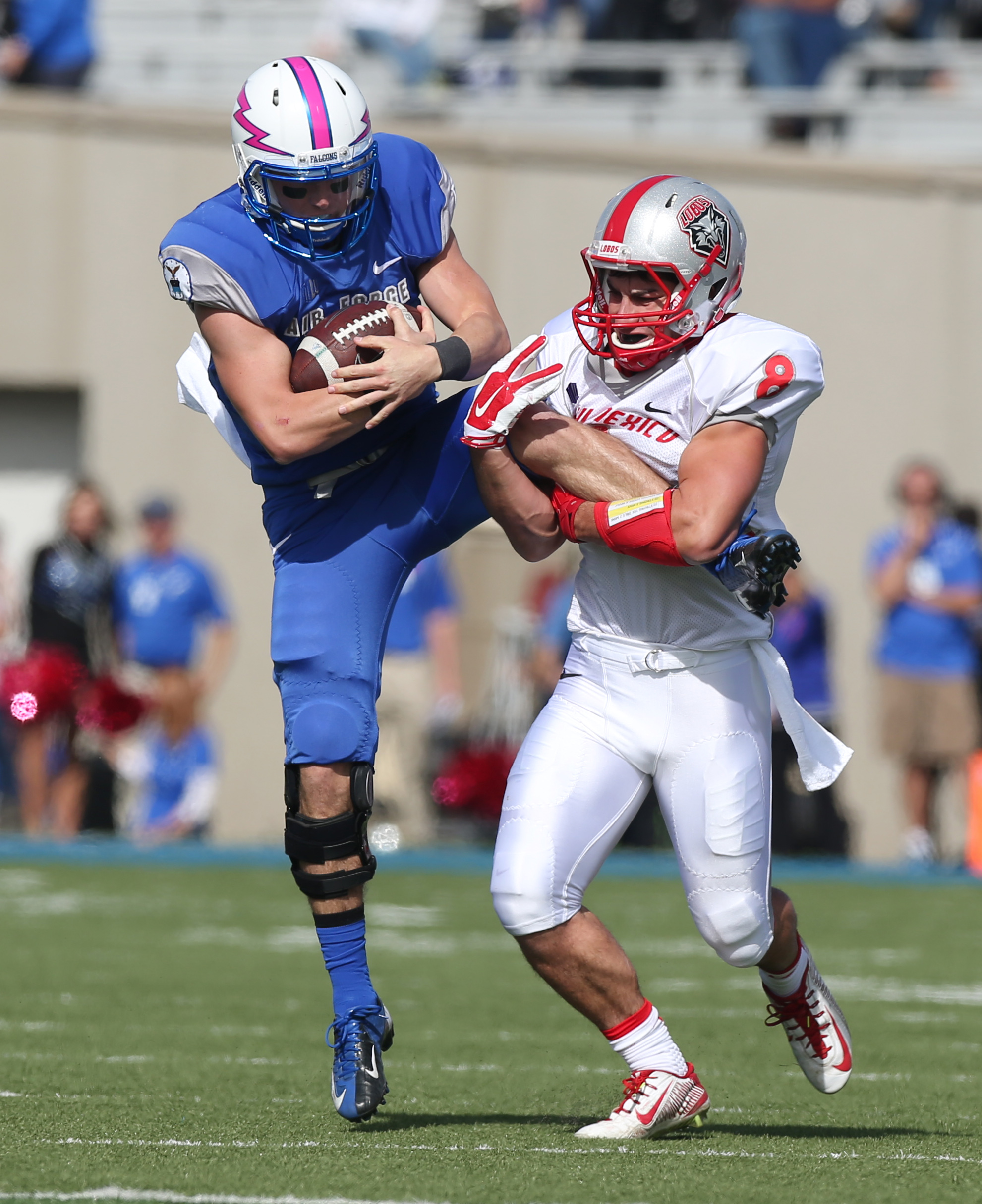 New Mexico defensive back David Guthrie, right, grabs the leg of Air Force quarterback Kale Pearson to make stop after short run in the first quarter of an NCAA college football game at Air Force Academy, Colo., on Saturday, Oct. 18. (AP Photo)