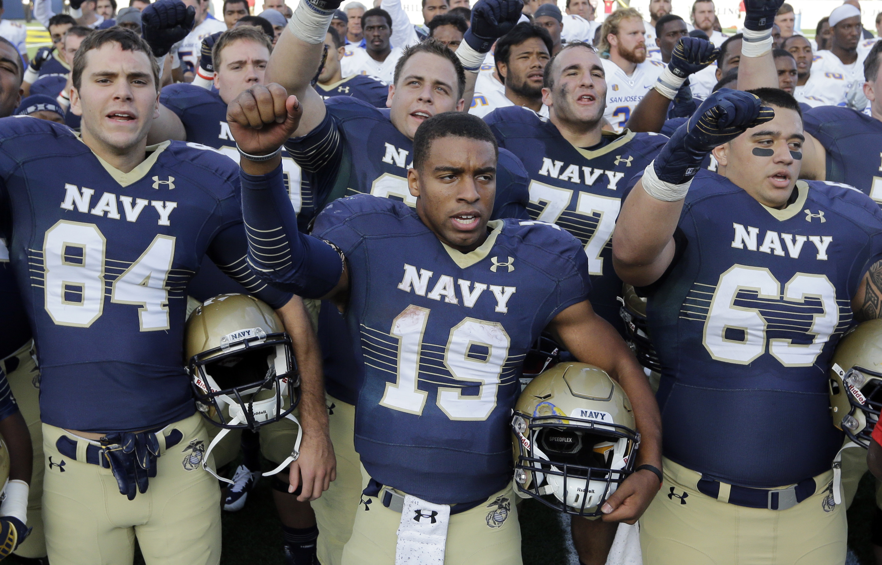 Navy quarterback Keenan Reynolds (19) sings the U.S. Naval Academy's alma mater alongside teammates after an NCAA college football game against San Jose State in Annapolis, Md., Saturday, Oct. 25, 2014. Navy won 41-31. (Photo: AP Photo)