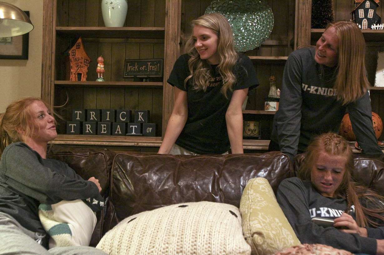 Jessica Smith, left, Monica Ramsey, center, McCall Smith, top right, and Cassidy Smith, bottom right, laugh while talking about a music video that McCall made with her younger siblings at the Smiths' home in Alpine, Utah, Thursday Oct. 16, 2014. The Smiths are triplets playing in their final soccer season together. (AP Photo/The Daily Herald, Ian Maule)