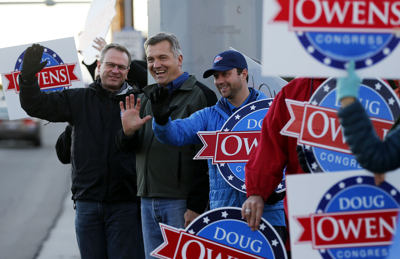 Doug Owens, left, candidate for United States Congress, waves to cars along with Congressman Jim Matheson in Taylorsville, Monday, Nov. 3, 2014. At right is Taylor Morgan, communications director for Owens. (Photo: Ravell Call, Deseret News).