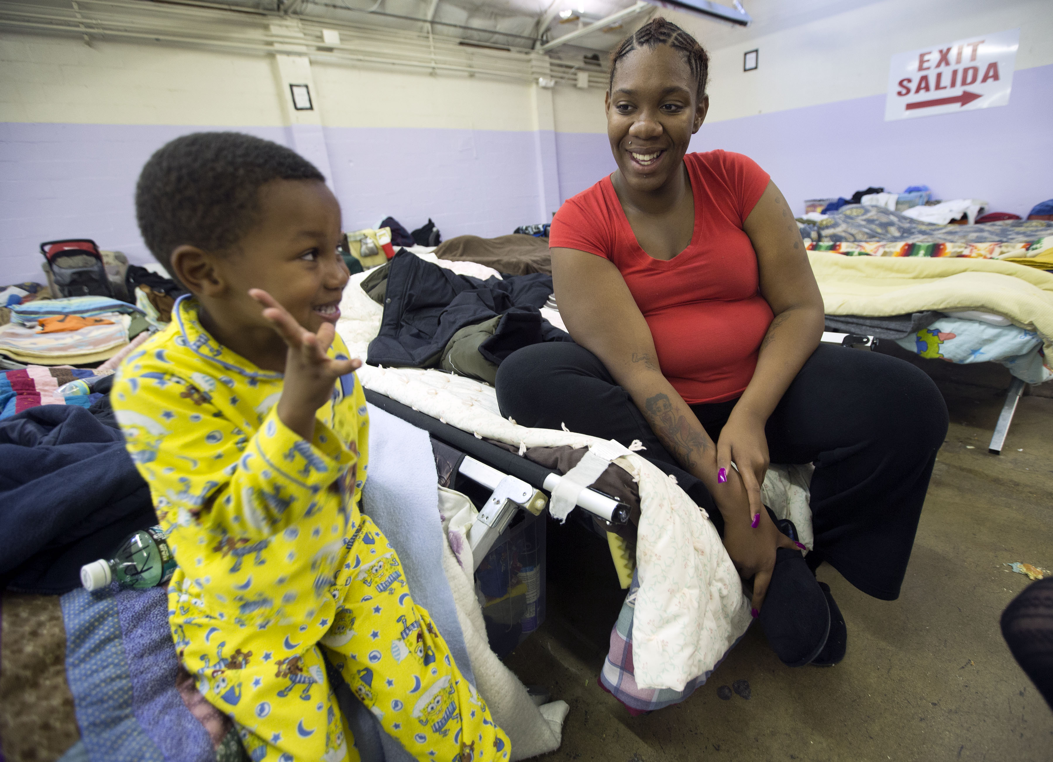Four-year-old Avanti Maxwell and his mother Kendra Hardrict, talk to each other Monday, Nov. 3, 2014, as they sit on their cots in the Midvale Road Home Shelter. (Photo: Scott G Winterton, Deseret News)