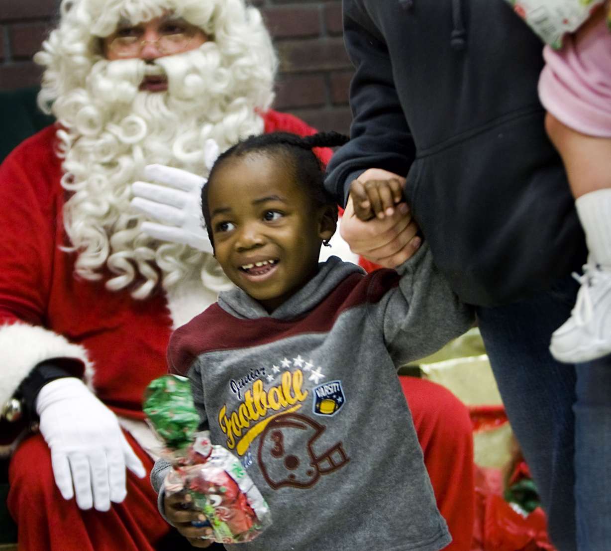 Jahmani Stapleton (2) grins after getting to meet the big man (Santa) at West High School in Salt Lake City on Saturday, Dec., 5, 2009. The event was sponsored by Soroptimist International of Salt Lake City. Single mothers were encouraged to come and have "Breakfast with Santa." With the help of volunteers the children were able to pick out and wrap gifts for their mothers while gifts were picked out for them in a different room. (Photo: Mike Terry, Deseret News) (Submission date: 12/05/2009)