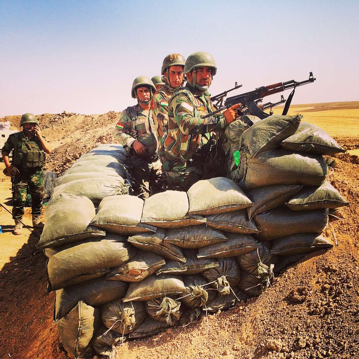 Kurdish fighters pose for cameras at a frontline position west of Erbil. After a panicked retreat last Wednesday, the Kurds have regrouped and are digging in and fortifying their defenses. Their commanders say American air strikes against ISIS have boosted morale among the Kurdish Pesh Merga. Credit: Ivan Watson/CNN