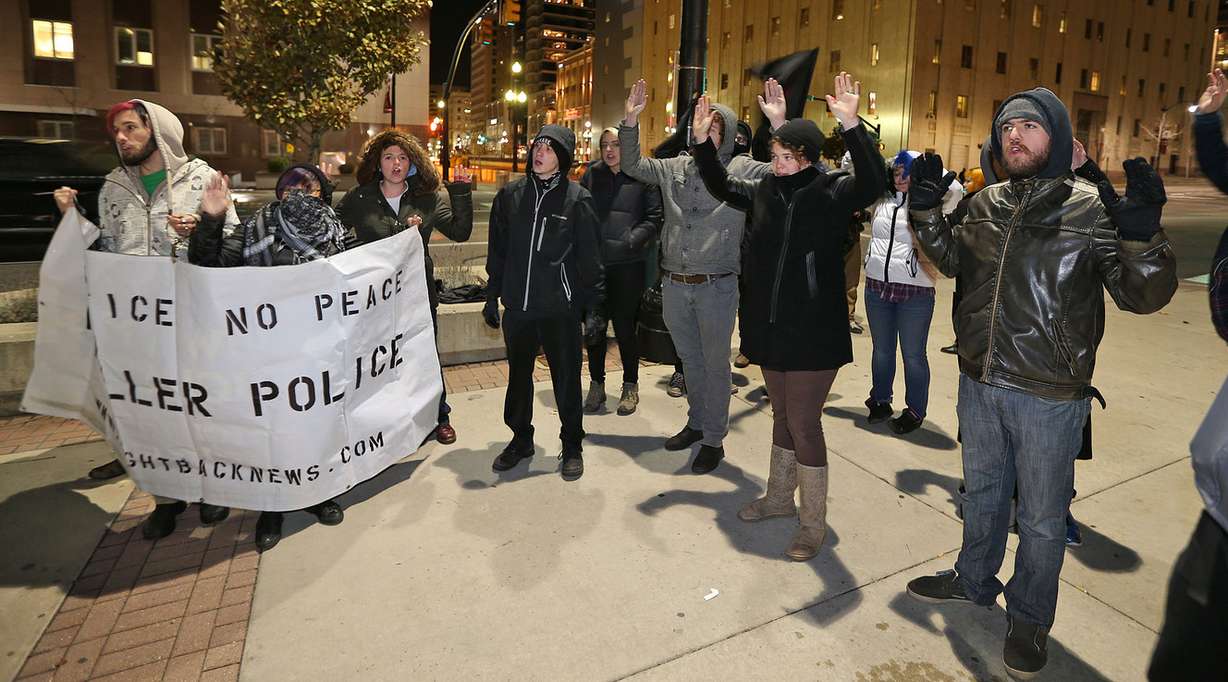 People protest, raising their hands and chanting, "Hands up! Don't shoot!" outside the Wallace F. Bennett Federal Building in Salt Lake City after a grand jury decision not to indict Ferguson police officer Darren Wilson in the death of Michael Brown was announced Monday, Nov. 24, 2014. (Photo: Tom Smart, Deseret News)