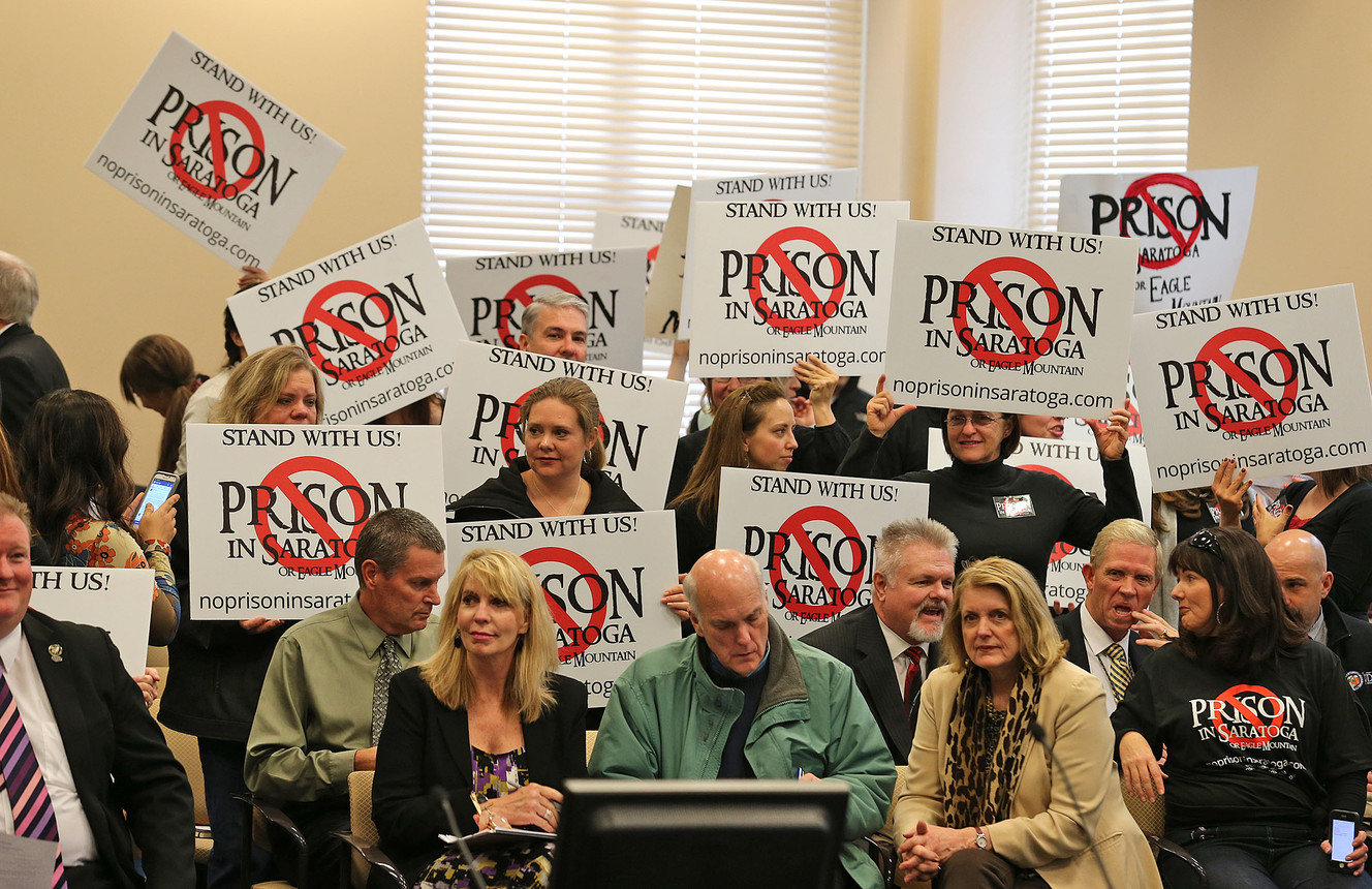 Protesters show their disapproval of relocating the Utah State Prison to near Saratoga Springs at the State Prison Relocation Commission meeting at the Utah Senate Office Building Wednesday, Dec. 3, 2014, in Salt Lake City. 
 (Photo: Tom Smart, Deseret News)