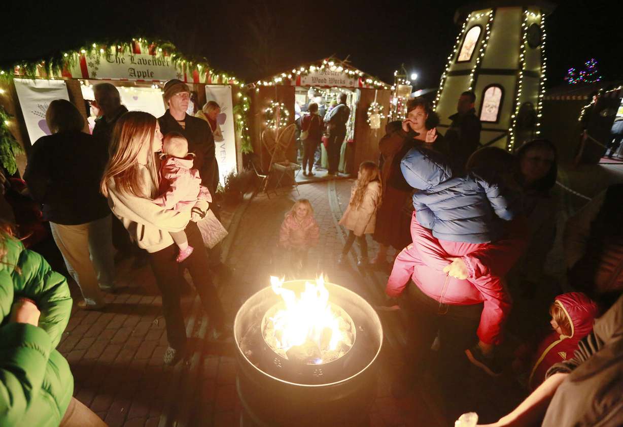Families stay warm by a fire during the Christkindlmarkt at the This is the Place Heritage Park Thursday, Dec. 4, 2014, in Salt Lake City. (Photo: Hugh Carey, Deseret News)
