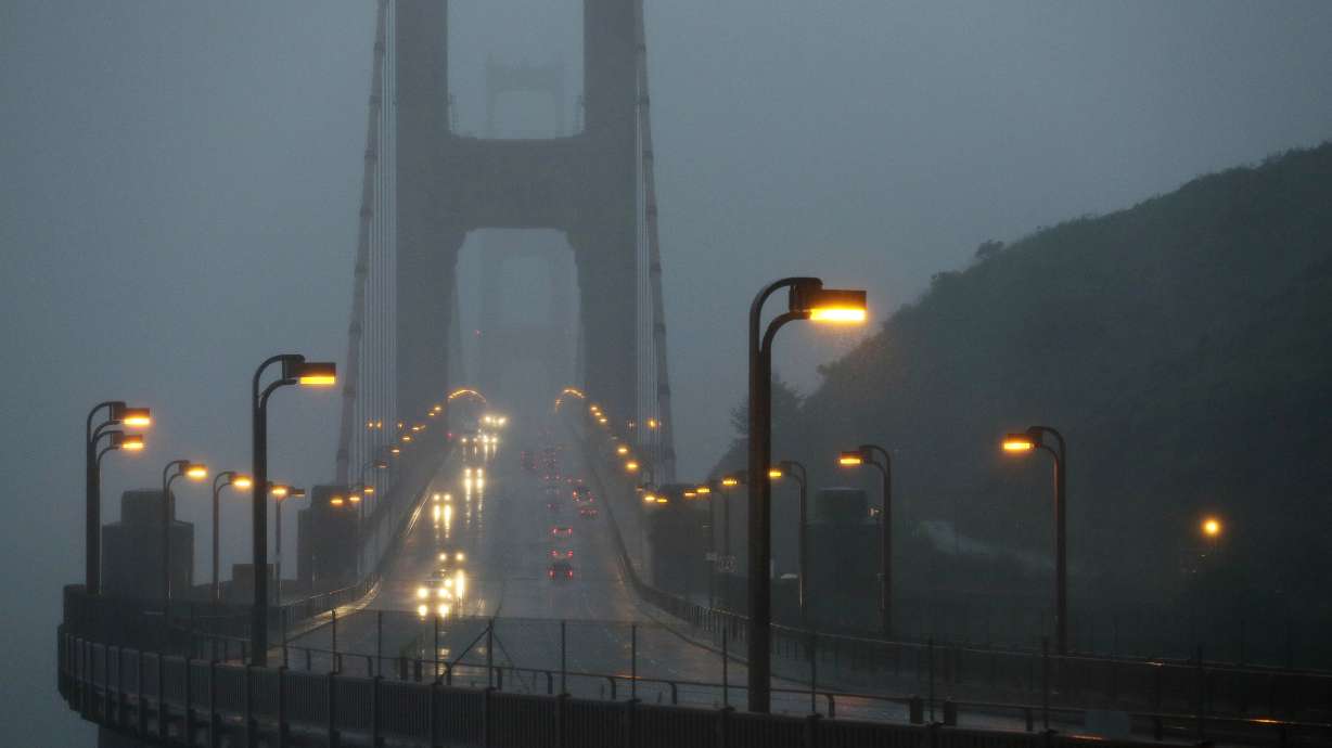 Traffic moves slowly across the Golden Gate Bridge in the high winds and rain Dec. 11, 2014, in this view from Sausalito, Calif. Weather forecasts say the West Coast will face "bomb cyclones" and "atmospheric rivers."