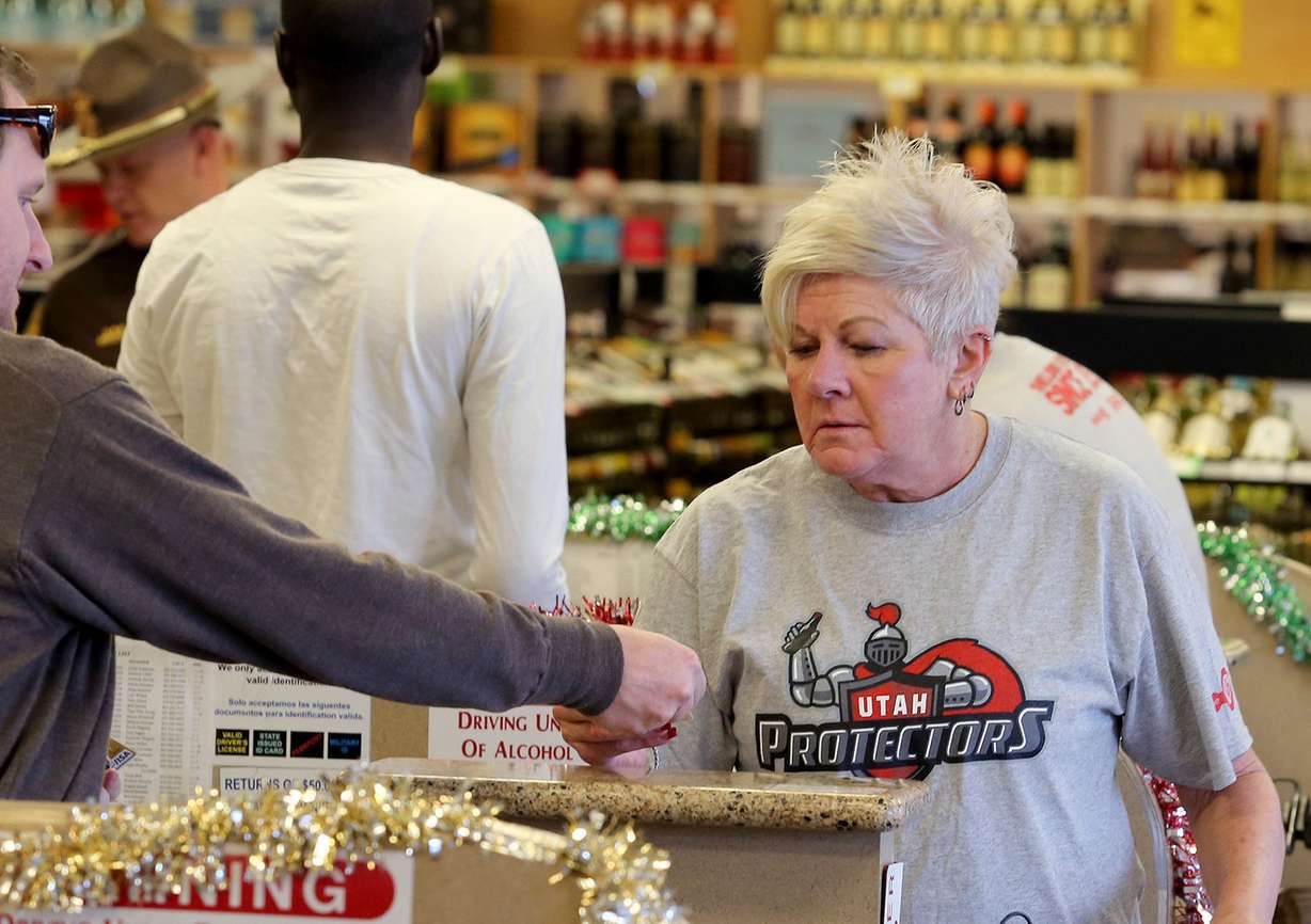 LaNae Smith checks ID before selling as part of the "The Utah Protectors" campaign announced in Utah liquor stores, Thursday, Dec. 11, 2014, in Salt Lake City. (Photo: Tom Smart, Deseret News)