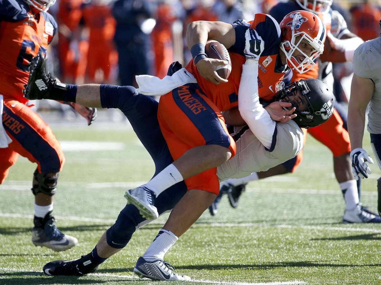 UTEP's Jameill Showers, front, is tackled by Utah State's Brian Suite during the first half of the New Mexico Bowl NCAA college football game Saturday, Dec. 20, 2014, in Albuquerque, N.M. (AP Photo/Ross D. Franklin)