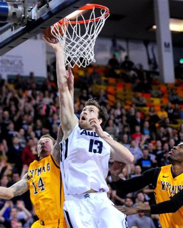 Utah State's David Collette (13) goes up for a layup while being guarded by Wyoming's Josh Adams (14) during an NCAA college basketball game, Tuesday, Jan. 27, 2015, in Logan, Utah. (AP Photo/Herald Journal, John Zsiray)