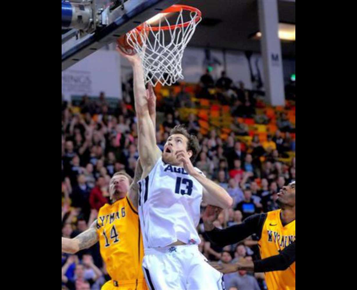 Utah State's David Collette (13) goes up for a layup while being guarded by Wyoming's Josh Adams (14) during an NCAA college basketball game, Tuesday, Jan. 27, 2015, in Logan, Utah. (AP Photo/Herald Journal, John Zsiray)
