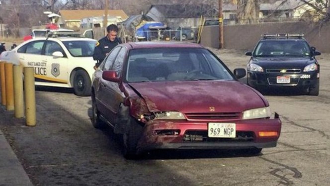 Hombre atrapa a policía con parte posterior de un auto robado hiriéndolo y huyendo luego en SLC
