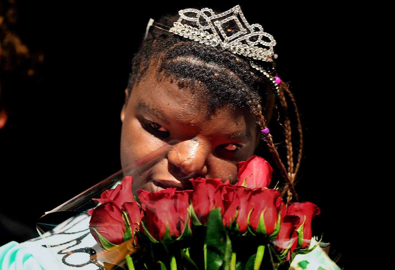 Jebbah Kamara touches her roses after being announced as junior prom queen during an assembly at Murray High School on Friday, Feb. 20, 2015. The high school's student body elected two students who have special needs as their prom king and queen. (Laura Seitz/Deseret News)